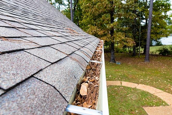 man using high-pressure hose to clean out gutters